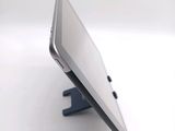 a tablet computer sitting on a stand on a white surface