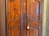 une grande armoire en bois dans le coin d'une pièce