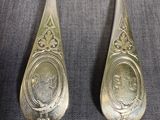 two silver spoons with a picture of a man and a woman on them