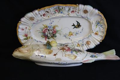 a fish shaped platter with a bird and flowers on it
