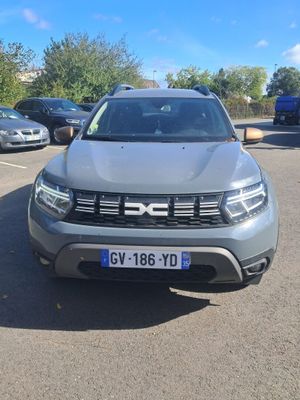 the front view of a grey dacia parked in a parking lot