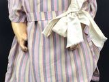 a small doll that is wearing a hat and dress