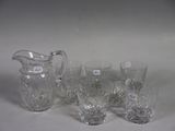 four glasses and a pitcher sitting on a table