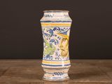 a blue and yellow vase sitting on a wooden table