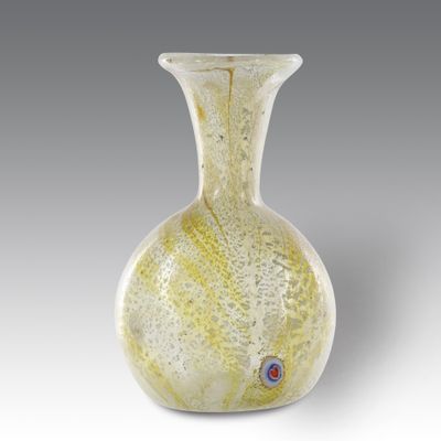 vase en verre jaune et blanc sur fond gris, orné d'un œil rouge