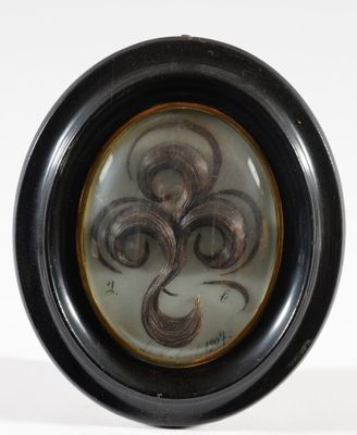 Médaillon ovale en cheveux figurant trois mèches disposées e…