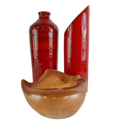 deux vases rouges et un bol en bois posés les uns à côté des autres
