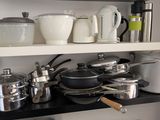 de nombreuses casseroles et poêles sur les étagères de la cuisine