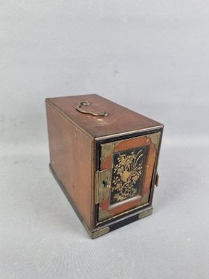 une petite boîte en bois sur laquelle est représentée une horloge