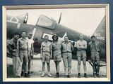 photo en noir et blanc d'un groupe d'hommes debout devant un avion