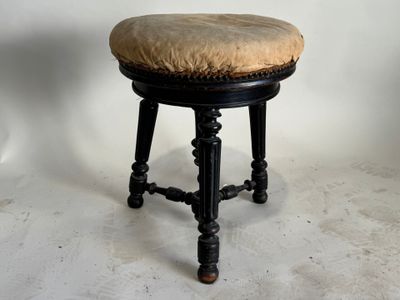 un tabouret noir surmonté d'un coussin beige