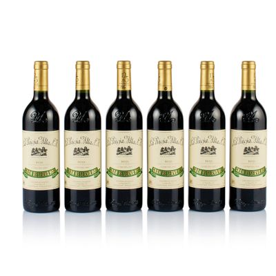 four bottles of wine are lined up on a white surface