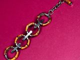 an image of a bracelet made of metal and wood with a cross on it