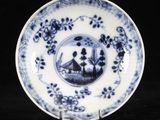 assiette bleue et blanche représentant un homme et une femme dans un bateau