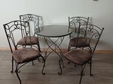 a glass table and four chairs in a room