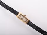 an image of a wrist watch with a gold case on a black rope