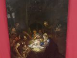 un tableau représentant une crèche avec un bébé dans la crèche, entouré d'autres personnes