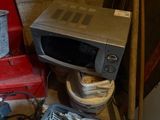 un micro-ondes posé sur une boîte
