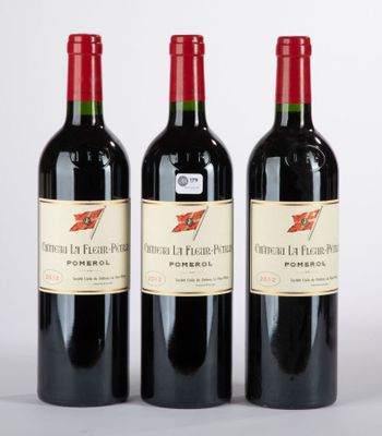 trois bouteilles de vin rouge posées côte à côte sur une table