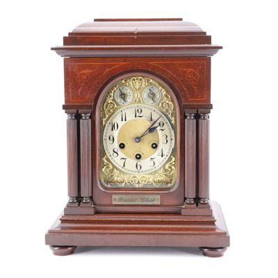 une horloge en bois posée sur une surface blanche