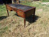 un bureau au plateau noir posé dans l'herbe