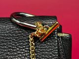 a picture of a black purse with a gold chain on it