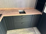 a kitchen counter with a sink and a stove in it
