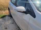 the car is parked on the side of the road near a field