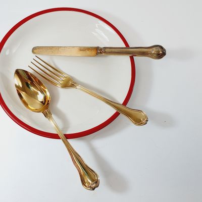 a red and white plate with silverware on it