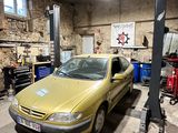 une voiture garée dans un garage équipé d'un pont élévateur