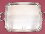 an antique silver tray with handles on a red background