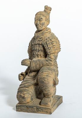 une image représentant la statue d'un homme assis sur un bloc de bois