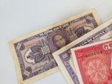trois anciens billets de banque chinois posés les uns à côté des autres sur une surface blanche