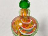 une bouteille en verre avec un tourbillon coloré à l'intérieur