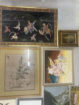 many framed pictures on the wall of this room