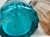 two glass vases sitting next to each other on a table