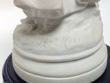a white statue of a woman sitting on top of a blue pedestal