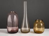 three different colored vases sitting on a white table