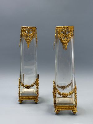 paire de vases en verre doré et transparent, rehaussés de touches dorées, posés sur des socles