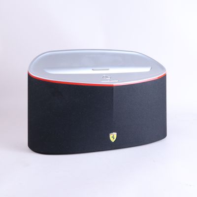 un gros plan d'une enceinte noire et rouge posée sur une surface blanche