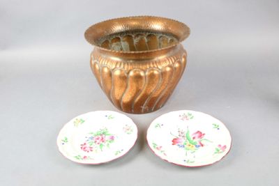 un vase en or et deux assiettes posées l'une à côté de l'autre