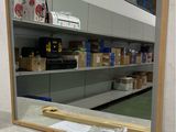 un miroir posé sur un comptoir devant une étagère