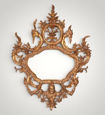 an ornate gold mirror with a bird and flower design