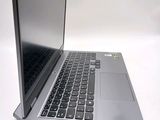 a silver laptop with a black keyboard on a white surface