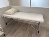 a white table with a pillow on it in the corner of a room