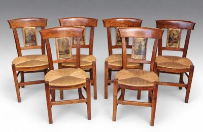 four wooden chairs with pictures on them sitting next to each other