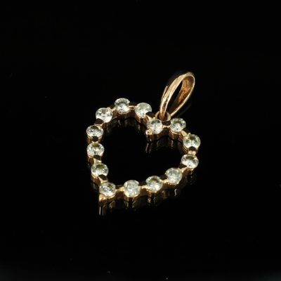 un pendentif en forme de cœur en or, serti de diamants, sur fond noir