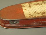 an old red suitcase with writing on it on a table