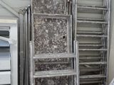 a room with a bed, ladders, and a microwave in it