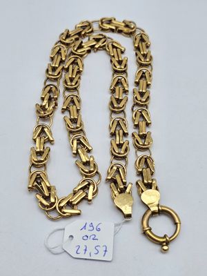 a close up of a gold chain on a white surface